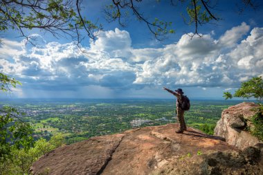Young man traveler on cliff with beautiful landscape clipart
