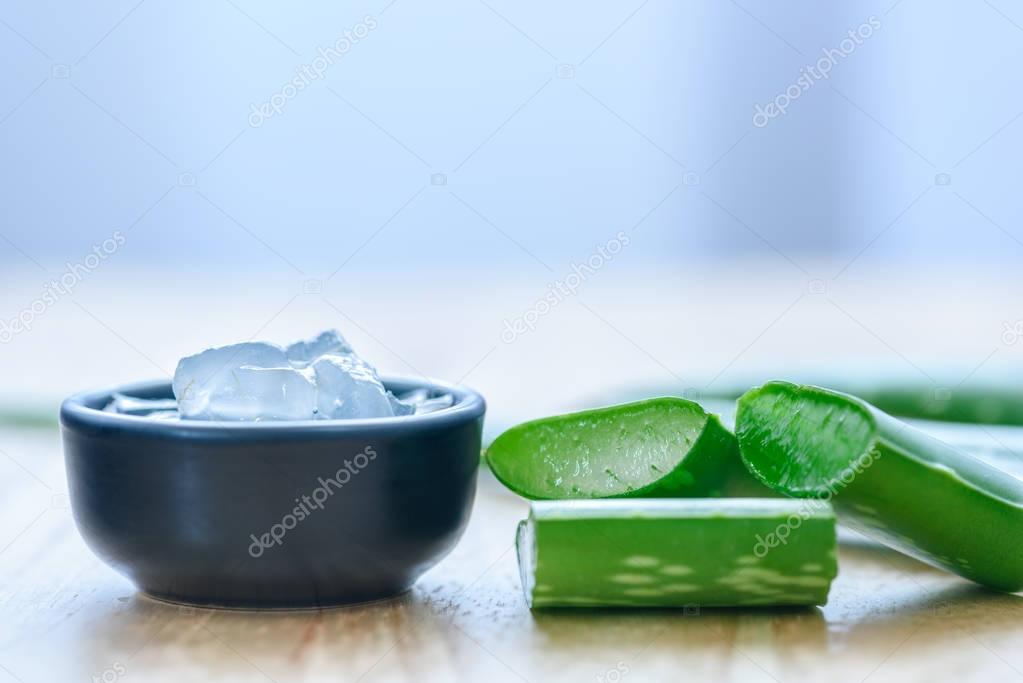 Aloe vera juice in bowl with fresh aloe vera leaves 