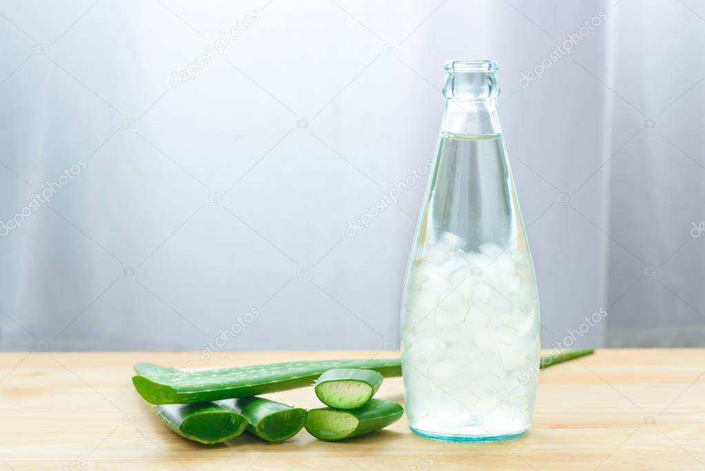 Aloe vera juice in bottle with fresh aloe vera leaves