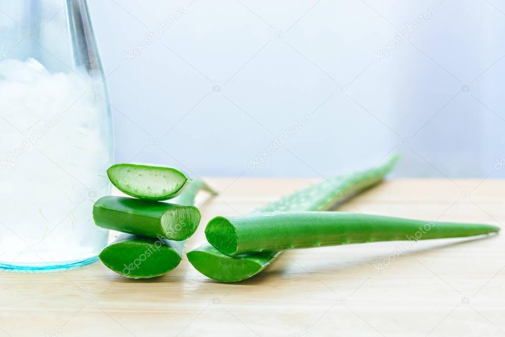 Fresh aloe vera leaves with aloe vera juice in bottle on wooden background