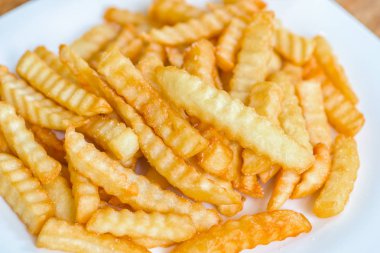 Ahşap arka planda patates kızartması.