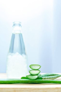 Taze aloe vera aloe vera suyu şişede ahşap arka plan üzerinde kalıyor
