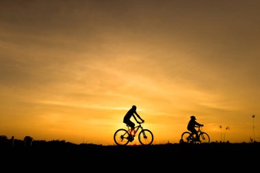 Gün batımı arka plan üzerinde bisiklet siluet