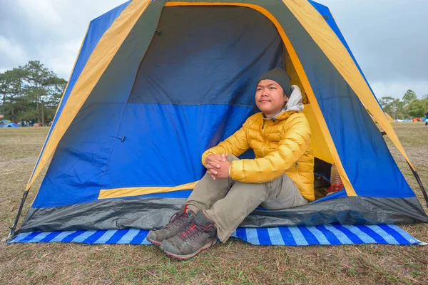 Mann sitzt auf dem Boden im Zelt beim Zelten — Stockfoto