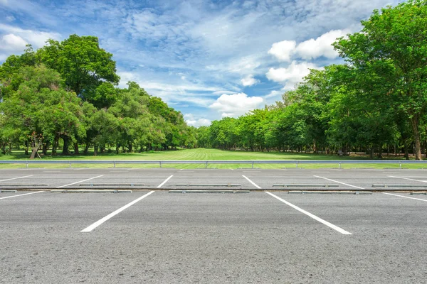Pusty parking przed zielony trawnik w parku miejskim — Zdjęcie stockowe