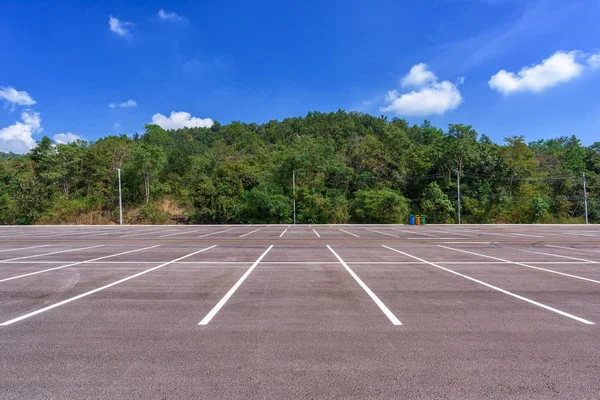 Orman ve güzel mavi gökyüzü ile boş park yeri.