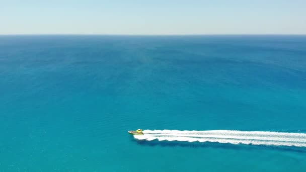 Vue aérienne Jaune Bateau à moteur naviguant dans l'eau bleue azur de la mer. Ayia Napa, Chypre — Video