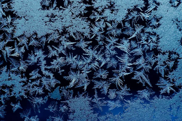 Frozen glass porthole and snowflakes on a blue background. — Stock Photo, Image