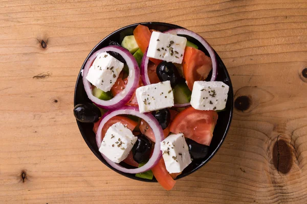 Greek salad on wooden table — Stock Photo, Image