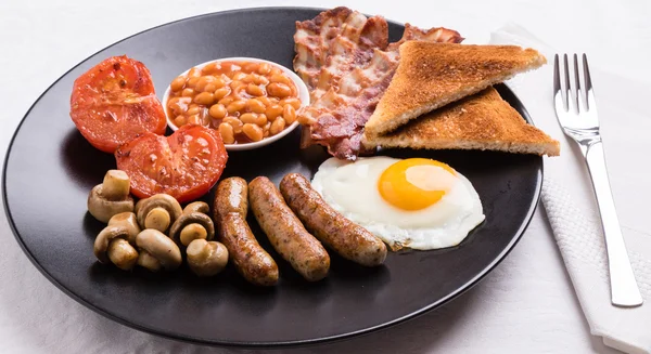 Englisches Frühstück auf schwarzem Teller — Stockfoto