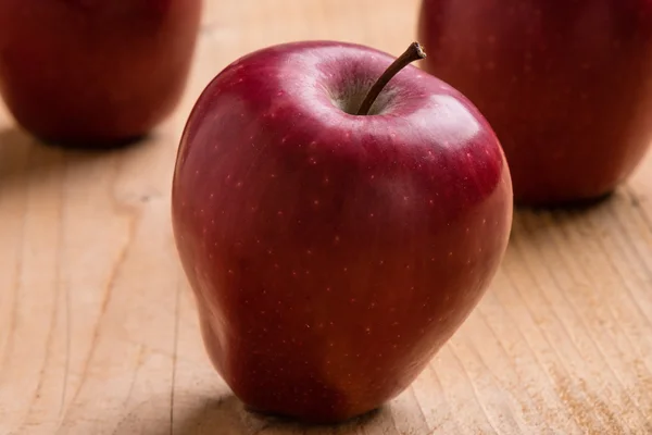Červené jablko na dřevěném stole — Stock fotografie