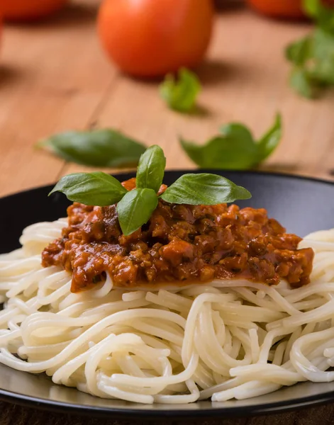 Spagetti bolognese på svart tallerken – stockfoto