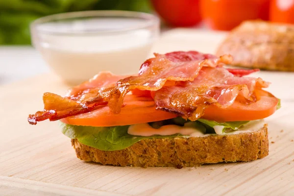 Sándwich de tocino sobre mesa de madera — Foto de Stock