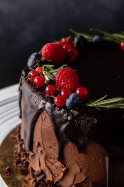 Kahverengi kremalı çikolatalı pasta ve köy usulü meyveler.