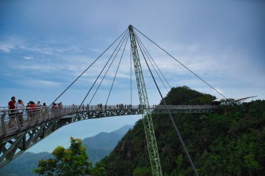 Langkawi, Malezya 12.08.2019: Muhteşem Langkawi Gökyüzü Köprüsü, yüksek dağ zirveleri arasında manzaralı yürüyüşler sunan, kavisli, kavisli bir halat destekli, asma köprü.