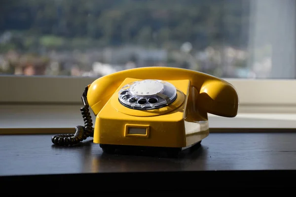 Old Retro Vintage Yellow Rotary Phone on black wood table — Stock Photo, Image