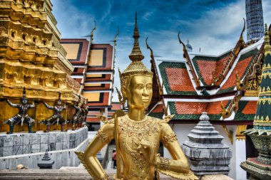 Bir Kinnara 'nın göz kamaştırıcı altın heykeli, Bangkok' taki Zümrüt Buddha Tapınağı 'ndaki Wat Phra Kaew' ın üst terasındaki efsanevi yarı insan, yarı kuş bir yaratık.
