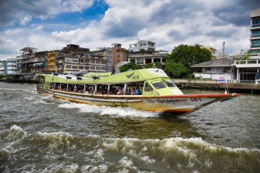 Chao Phraya Ekspres Teknesi, Bangkok Çin Mahallesi 'nin arka planında Chao Phraya Nehri' nden yerel yolcu, yolcu ve turistleri taşıyor.