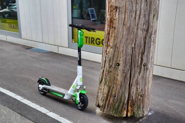 Modern, elektrikli kireç Zürih sokaklarında bir sandığın yanında scooter 'ı paylaşıyordu.
