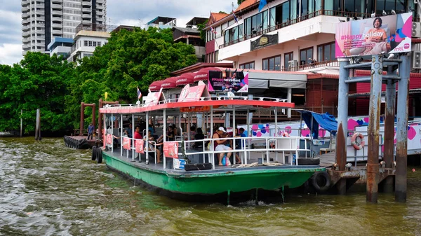 A tourist sightseeing boat with passengers is about to depart from the colorful Chinatown boat station alongside the Chao Phraya River — Stock Photo, Image