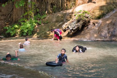 Tenasserim Hills, Sai Yok Bölgesi, Kanchanaburi Eyaleti, Tayland 12.28.2019: Taylandlı çocuklar ve ebeveynleri sonbaharın ferahlatıcı sularının keyfini çıkarıyor ve dinleniyorlar