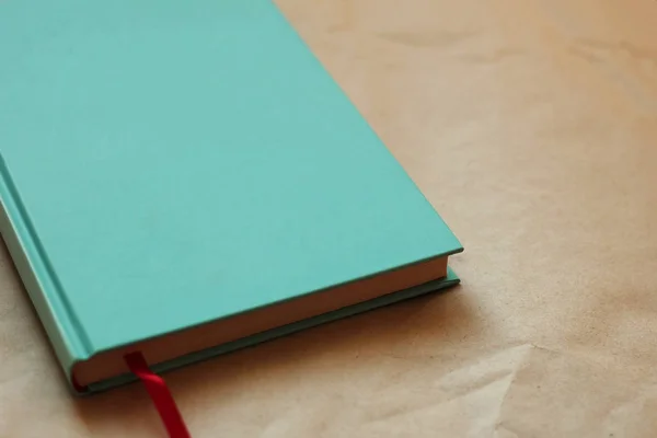 Kraft kağıdında kırmızı yer imi olan nane rengi bir kitap. Boş kitap kapağı. Boş boşluklu kitap kapağı. Tasarım stili için kitap içeren arkaplan