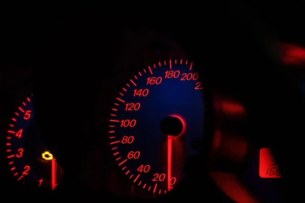 Geceleri arabasında parlak neon ışıklar olan gösterge paneli. Neon aydınlatmalı hız göstergesi