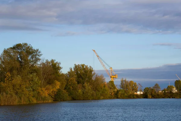 A beautiful view on lake near city buildings and crane. A beautiful landscape near Kherson, Ukraine