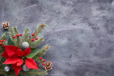 Köknar dalları, poincettia ve Xmas dekorasyonlarıyla düz yatıyordu.