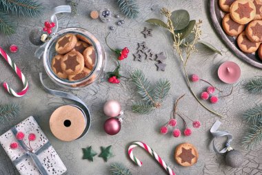 Çeşitli Xmas süslemeleri ve şeker kamışı ile çikolata yıldız desenli Noel kurabiye. Düz koyu rustik ahşap arka plan üzerinde yeşil ve pembe yatıyordu.