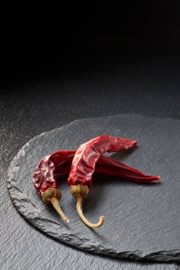 Slate Stone arka planında iki kuru kırmızı biber. Gıda arkaplanı.