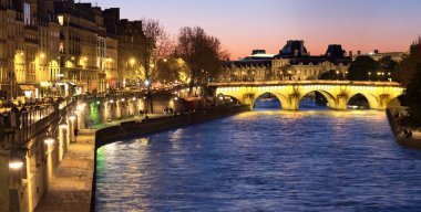 Akşam Paris, Seine nehrine doğru ışıklı Pont Neuf bir gün batımı Tarih boyunca panorama görüntüyü.