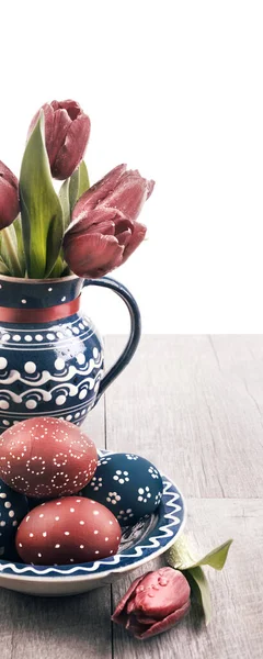蓝色陶瓷花瓶 郁金香和匹配板画的复活节彩蛋 木制的桌子上 — 图库照片