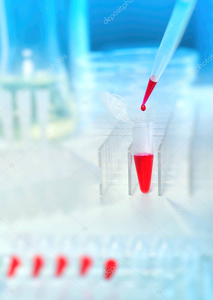 Scientific or medical background. Loading of red liquid sample with automatic pipette, closeup, copy space