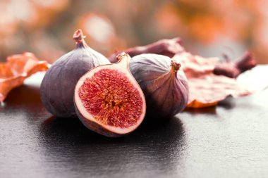 Taze incirlere, açık havada parlayan taştan tabaklara yakından bak.