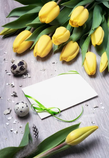Tarjeta de felicitación en blanco con tulipanes y huevos de codorniz en madera — Foto de Stock
