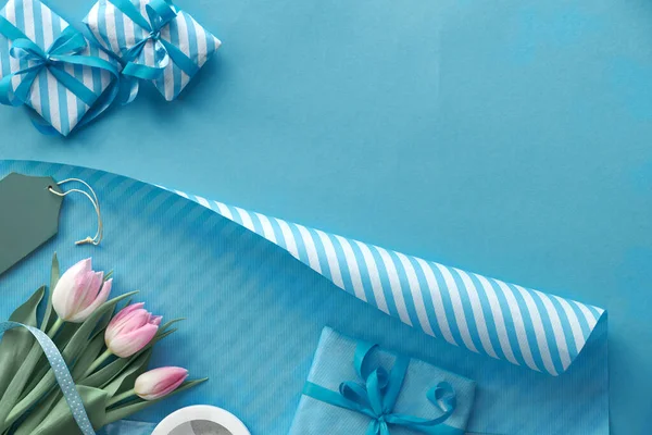 Blauwe Achtergrond Met Roze Tulpen Gestreept Inpakpapier Ingepakte Geschenkdozen Kopieerruimte — Stockfoto