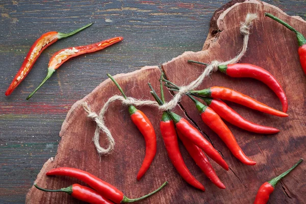 Close-up op rode hete chili pepers op donker hout, plat gelegd — Stockfoto