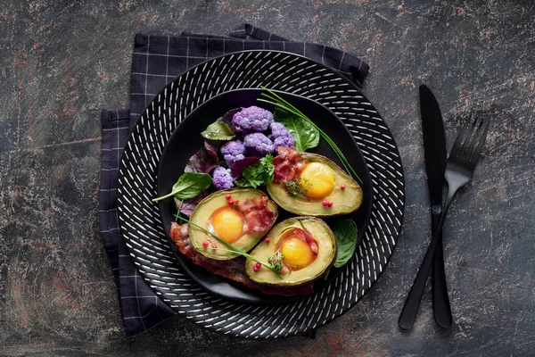 Gebakken avocado met ei en spek, platte lay op donkere achtergrond — Stockfoto