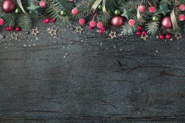 Noel arkaplanı yeşil köknar dalları, kırmızı böğürtlenler ve desenli siyah tahta metin alanındaki şeker kamışlarıyla