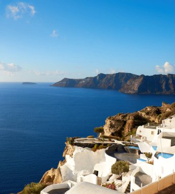 Yunanistan 'daki güzel Santorini - Oia köyündeki volkanik kalderaya bakan evler ve daireler, panoramik görüntü