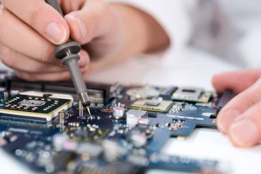 Technological background with closeup on tester checking motherboard. Blurred image for your text on top. Shallow DOF, exact focus on the tester tip