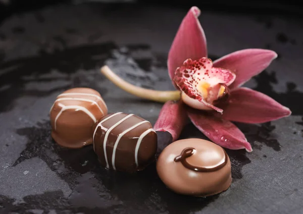 Chocolate Pralines Rchid Flower Black Stone Surface — Stock Photo, Image