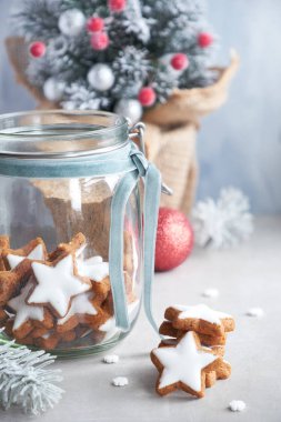 Christmas background in green and blue with tasty star ginger cookies in a glass jar and decorated  Xmas tree