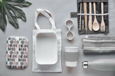 Yaratıcı üst görünüm, sıfır atık beslenme çantası, paket yemek paketi, bambu çatal bıçak takımı organizatörü, yeniden kullanılabilir kutu ve bambu kahve fincanı. El işi kağıdında sürdürülebilir yaşam tarzı düzlemi.