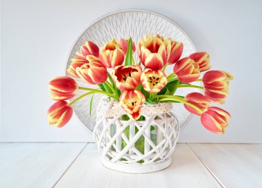 Beyaz ahşap arka plan üzerinde kırmızı-sarı lale demet, merkezi kompozisyon