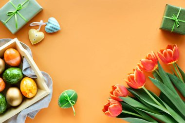 Paskalya dairesi turuncu kağıdın üzerinde fotokopi alanı ile duruyordu. Dekoratif tepside boyanmış yumurtalar, bahar laleleri, hediye kutuları ve kalp süslemeleri..