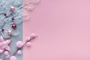 Dekoratif beyaz kış dalları, donuk geometrik yapraklar, yumuşak tekstil mücevherleri ve dağınık cam Xmas ıvır zıvırları. Noel dairesi iki renk pembe ve gümüş kağıt üzerine kuruluydu..
