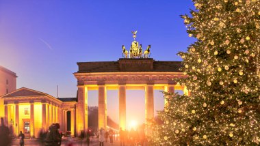 Berlin 'deki Brandenburger Kapısı' nın panoramik görüntüsü. Akşam aydınlatmalı bir günbatımında Noel ağacı.. 