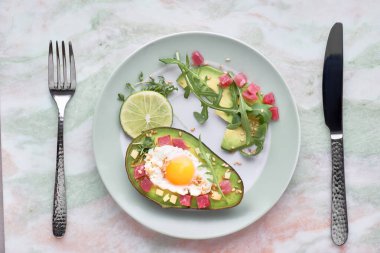 Keto diyet yemek: jambon küpleri ile pişmiş Avokado tekne, bıldırcın yumurtası ve peynir yeşil rucola salata ile servis